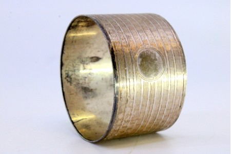 Argola de guardanapo em prata com bandas guilhochadas envolvendo cartela para monograma.